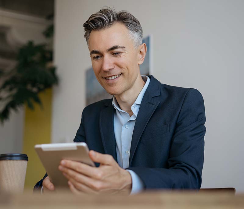 Man in a suit using a tablet